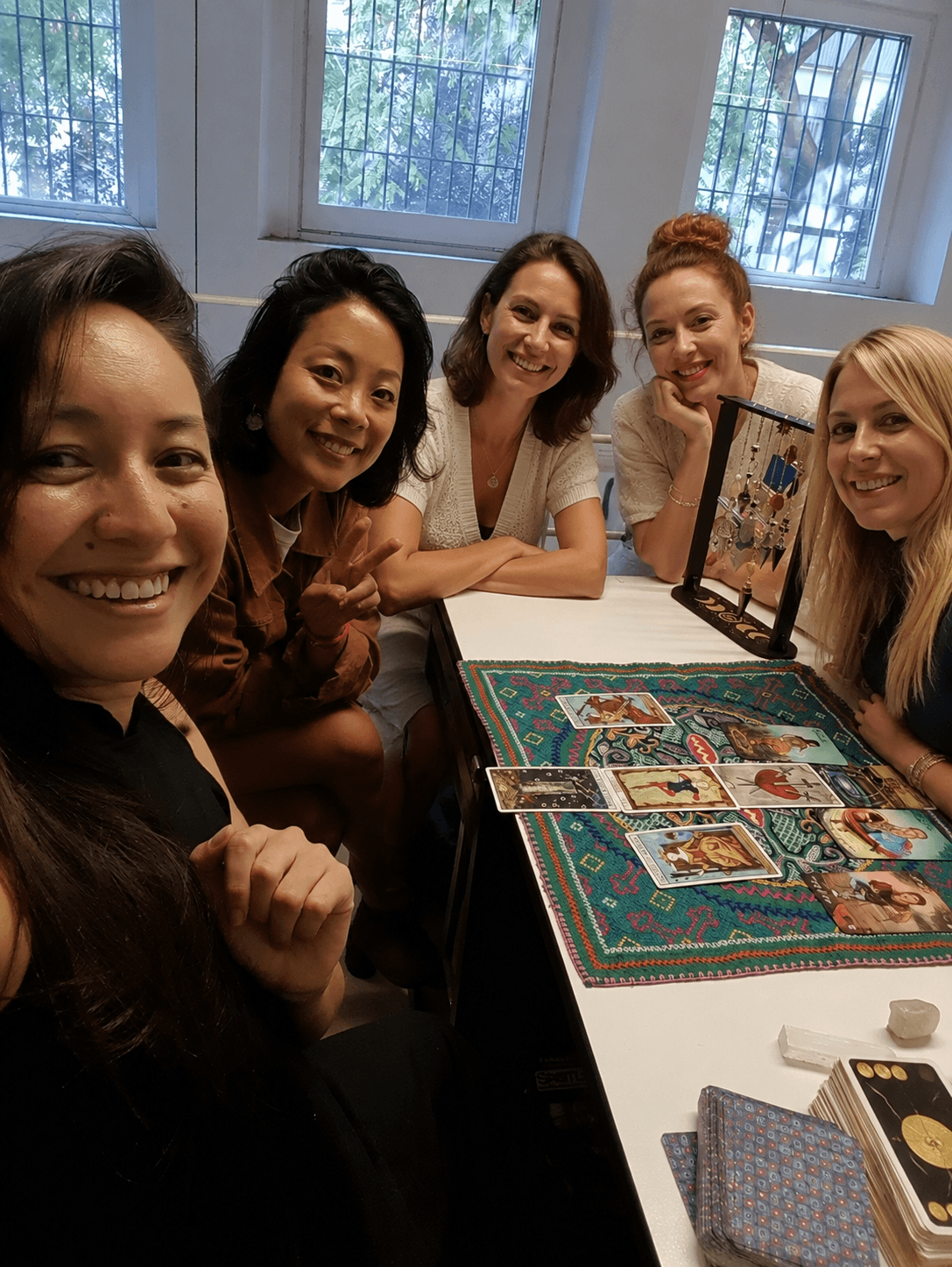 Groupe de filles autour d’une table pendant une animation tarot EVJF à Barcelone